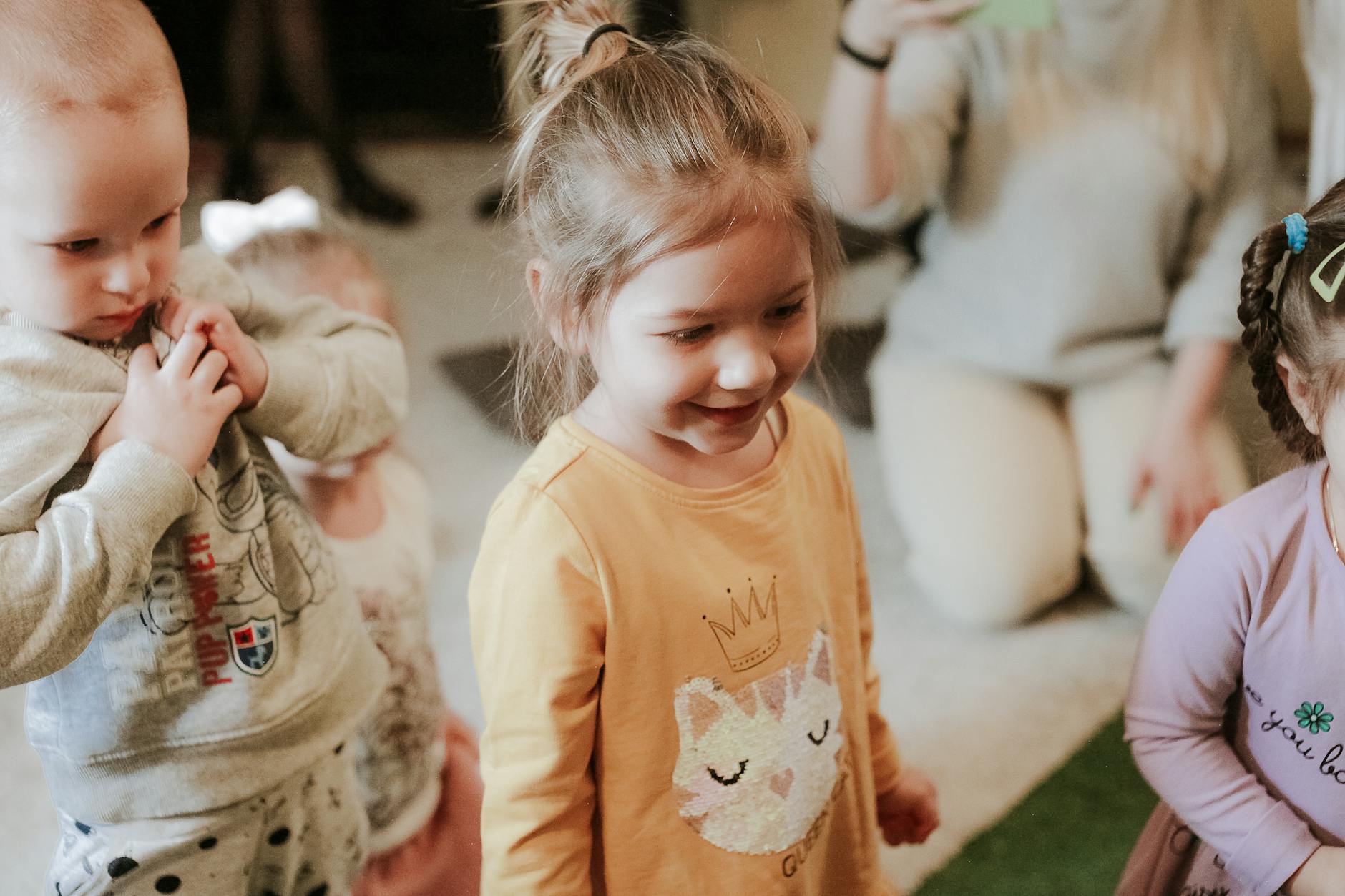 Ilustracja przedstawiająca uśmiechnięte dzieci bawiące się na nowoczesnym placu zabaw, symbolizujące dotacje dla przedszkoli w Lubartowie.